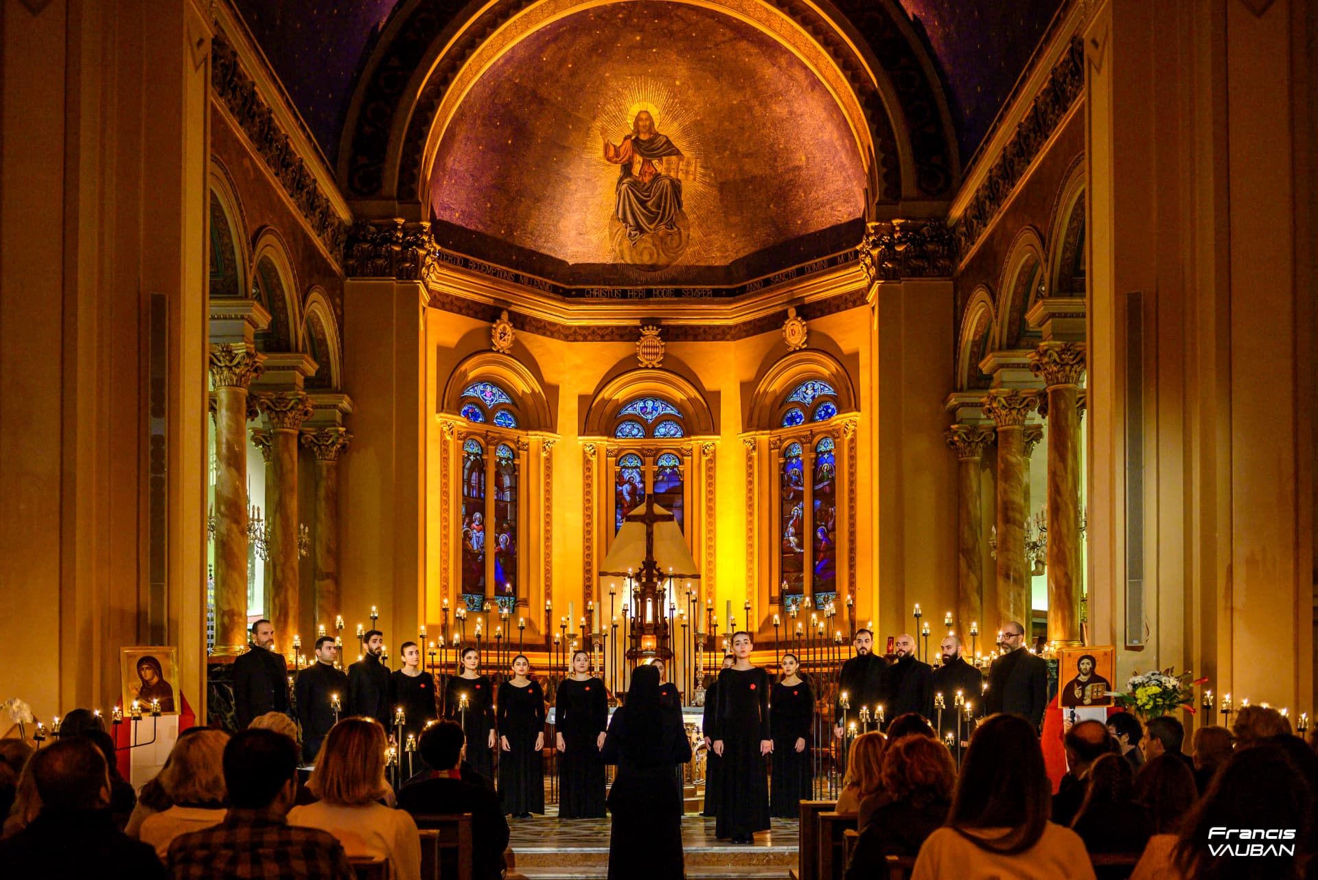 Vue d'ensemble du chœur et du public dans une église entourée de bougies